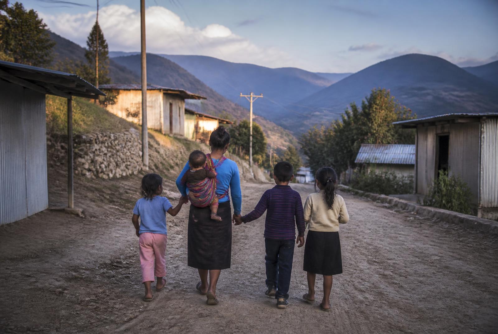 A family walking through a remote mountain village in Latin America