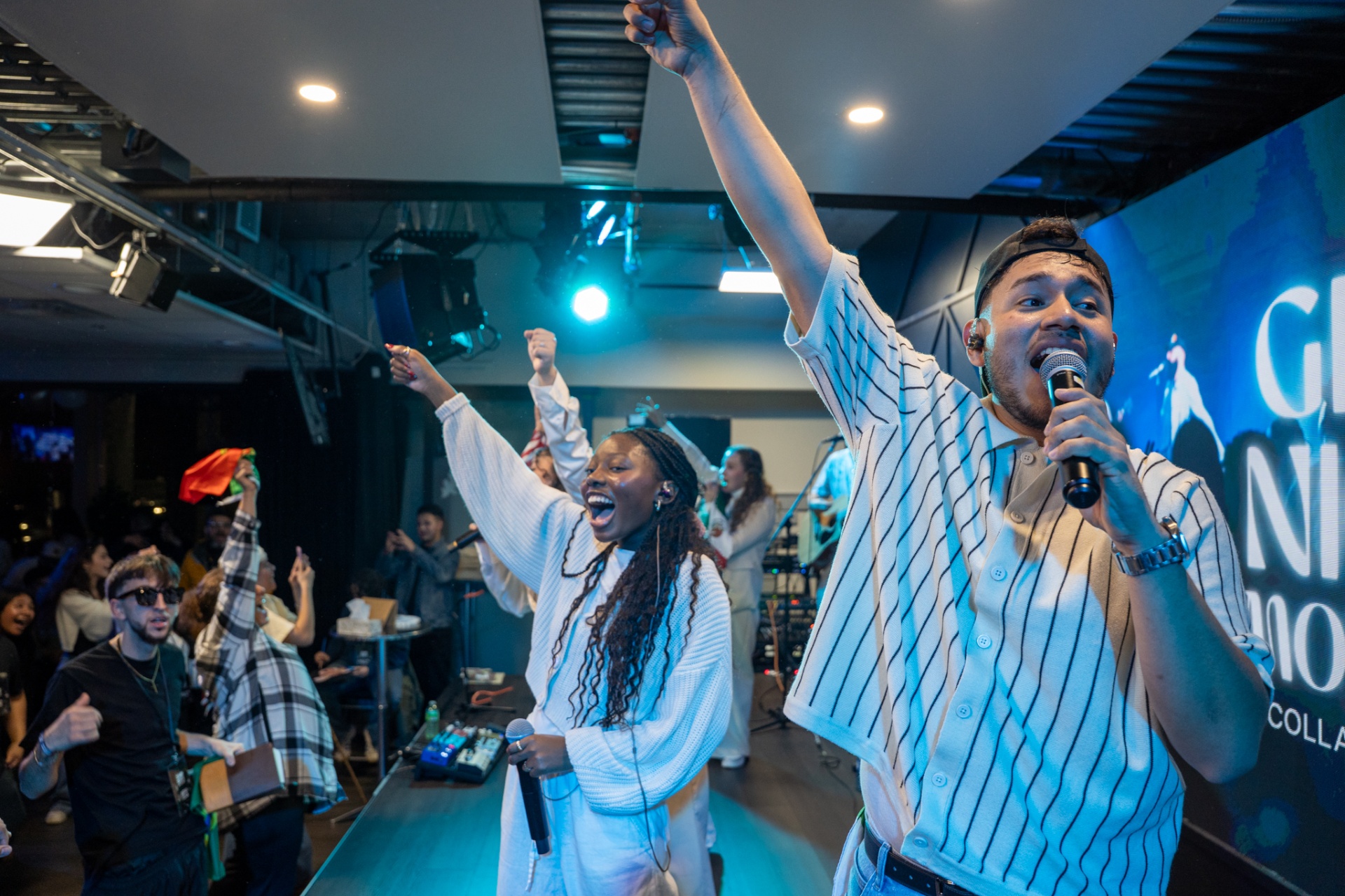 Worship leaders singing on stage at a Worship Nights gathering